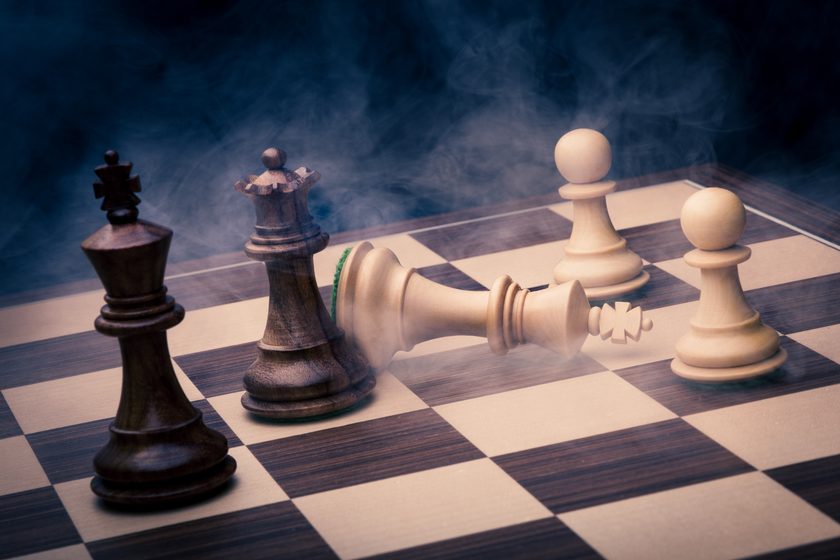 fallen white king on a chessboard among standing pieces, smoke in blue light